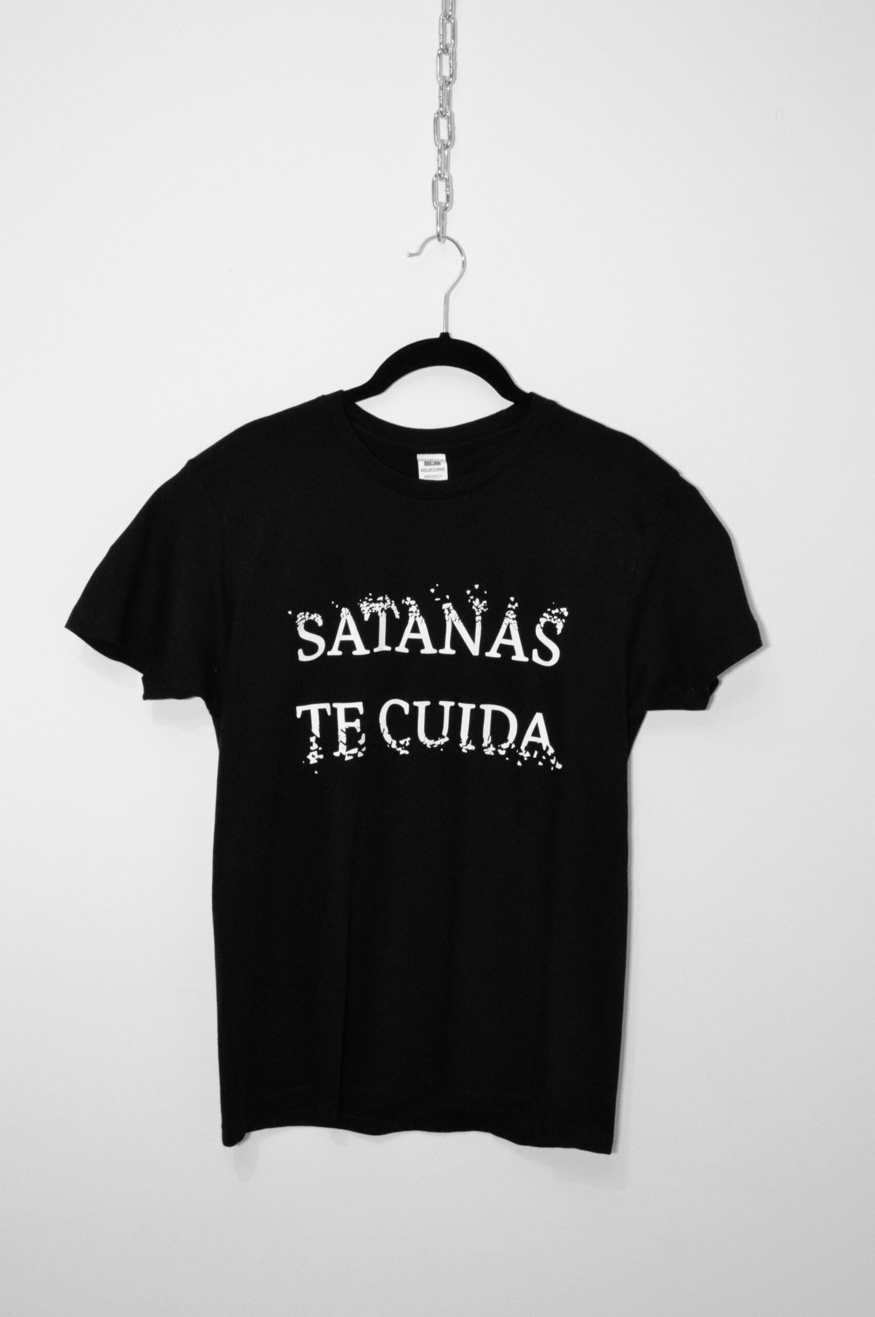 Camiseta manga corta con mensaje: Satanás te cuida desgastado en el pecho